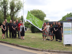 Cllr Beresford and ward members with staff from the Council, Dignity and Glendales at the Green Flag Award flag at Rotherham Crematorium.