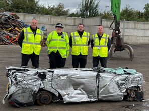 Council staff with a crushed car.