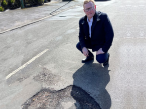 Cllr Beck next to a pothole in Rotherham.