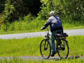 Older man riding a bicycle along a cycle lane