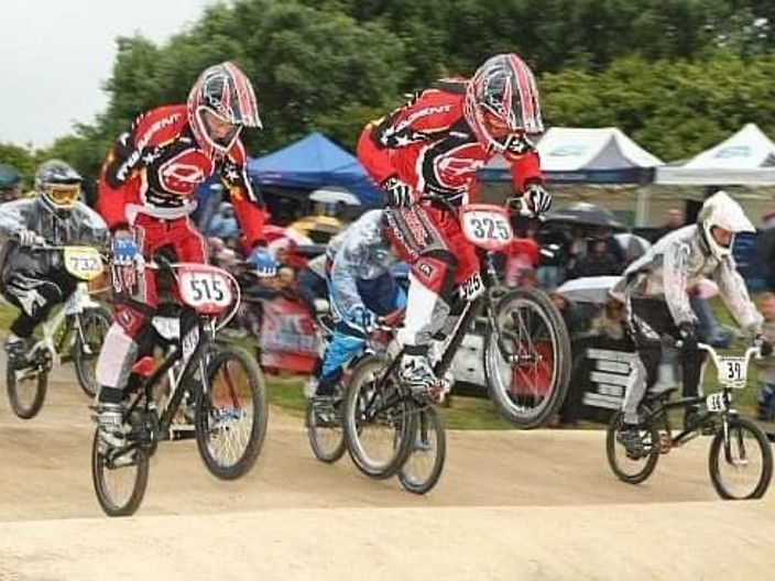 BMX racing with riders going over jumps