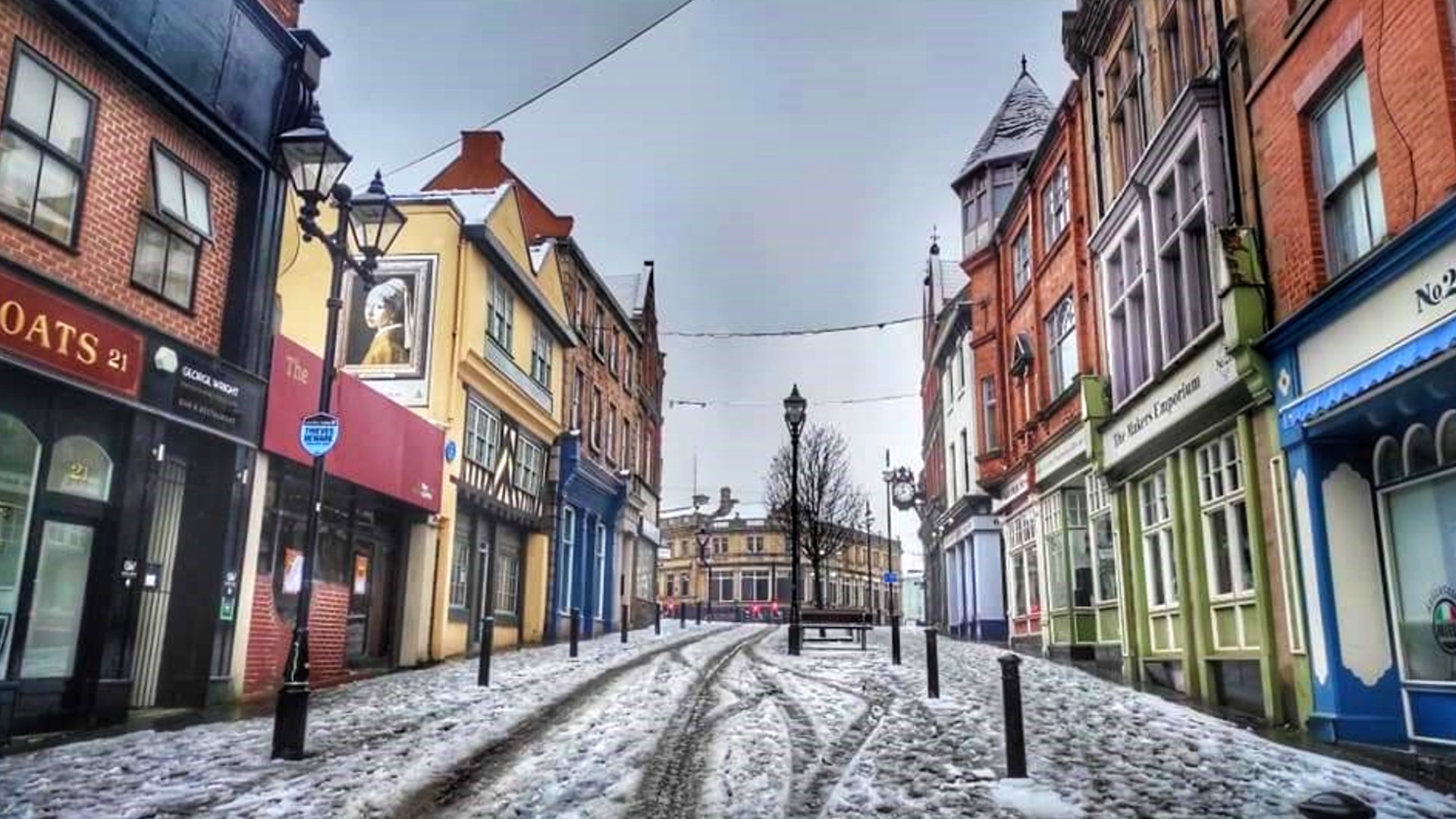 Rotherham High Street in the snow with shops on either side of the street