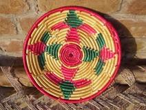 Picture of a woven basket made with pink, green and brown strands.