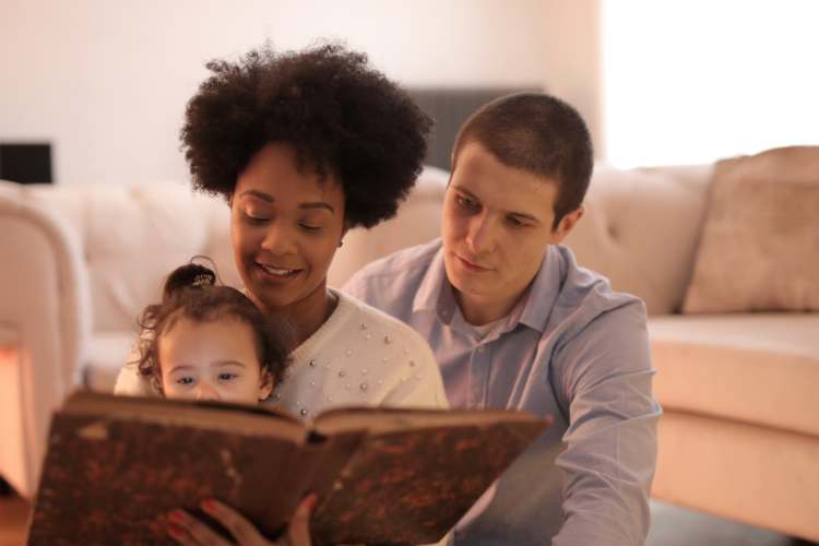 kinship carers reading a book to child
