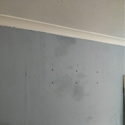 Damp near the top of a grey painted wall