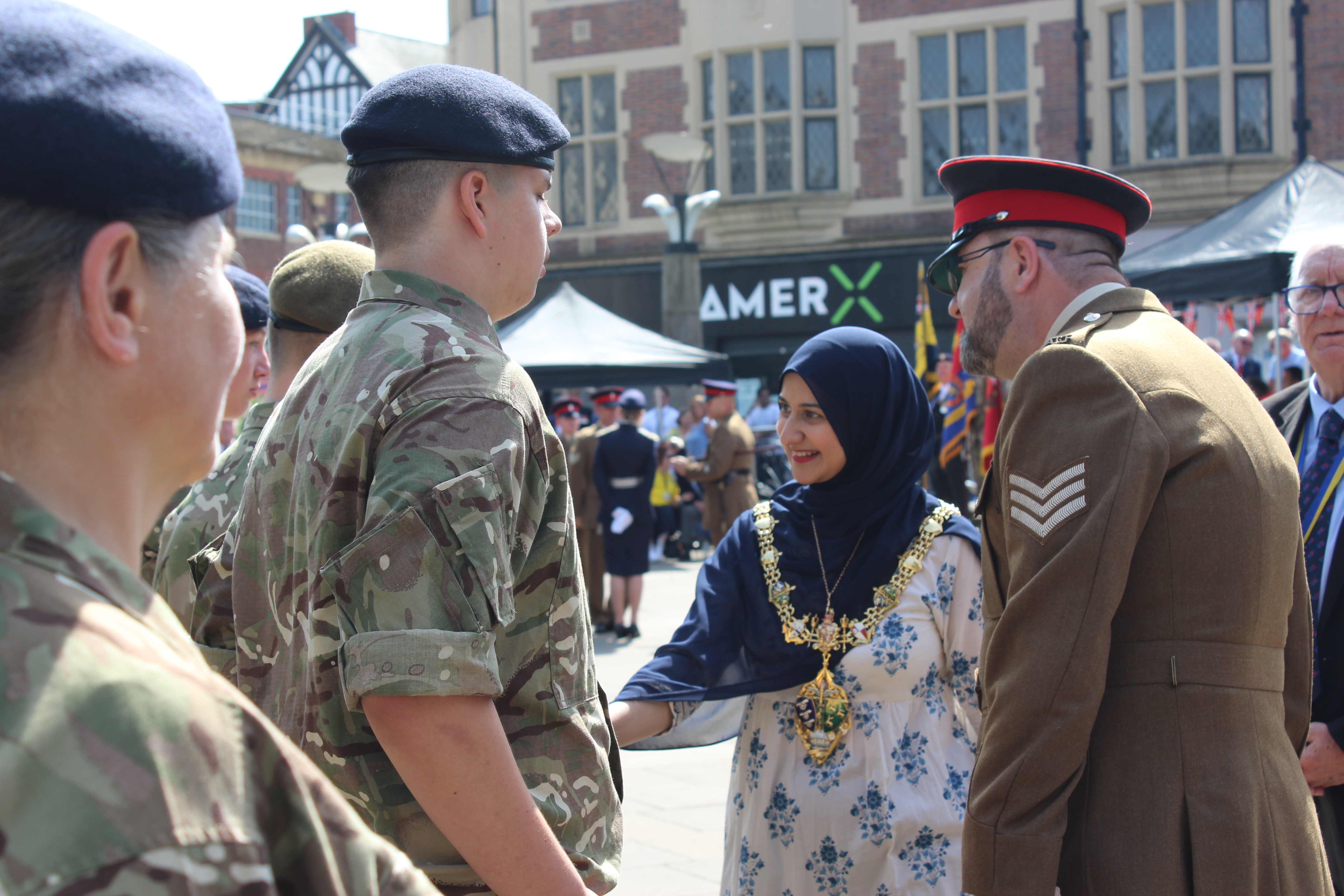Military personnel in uniform greeting the Mayor.