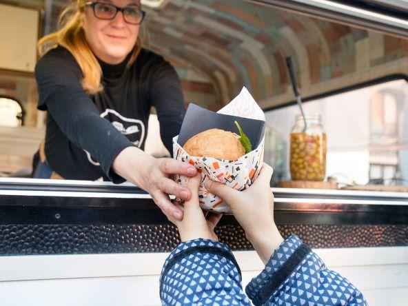 Woman serving from a mobile catering van.