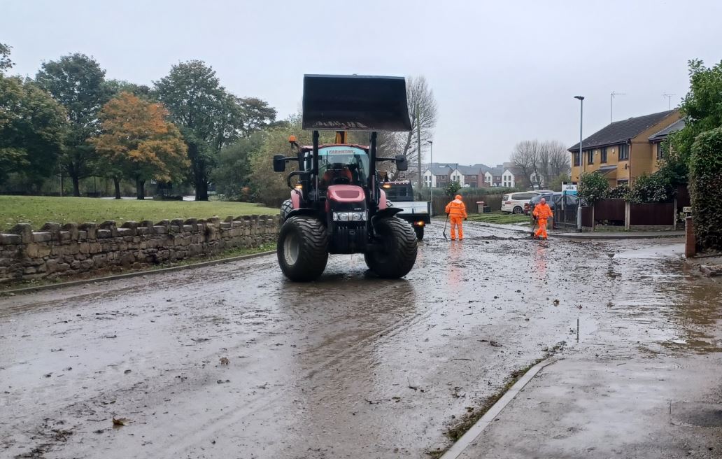 Staff cleaning street with shovels