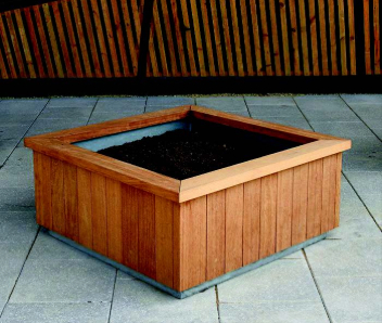 A light brown wooden flower planter with soil inside.