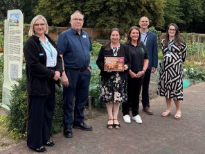 Rotherham Food Network members stood inside Clifton Park Walled Gardens holding the certificate