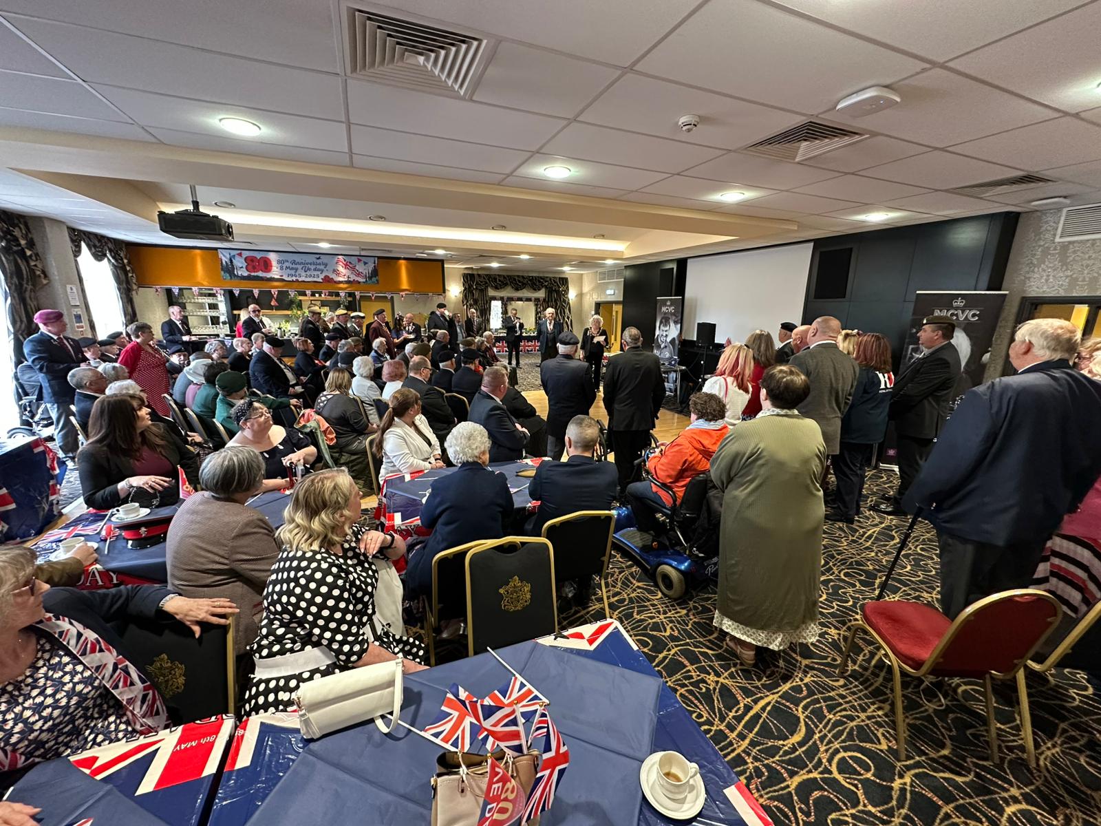 Members and veterans celebrating VE Day 80th Celebrations 2025 inside the town hall