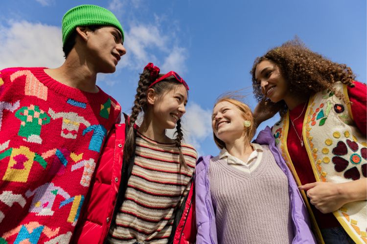 four people stood smiling at each other