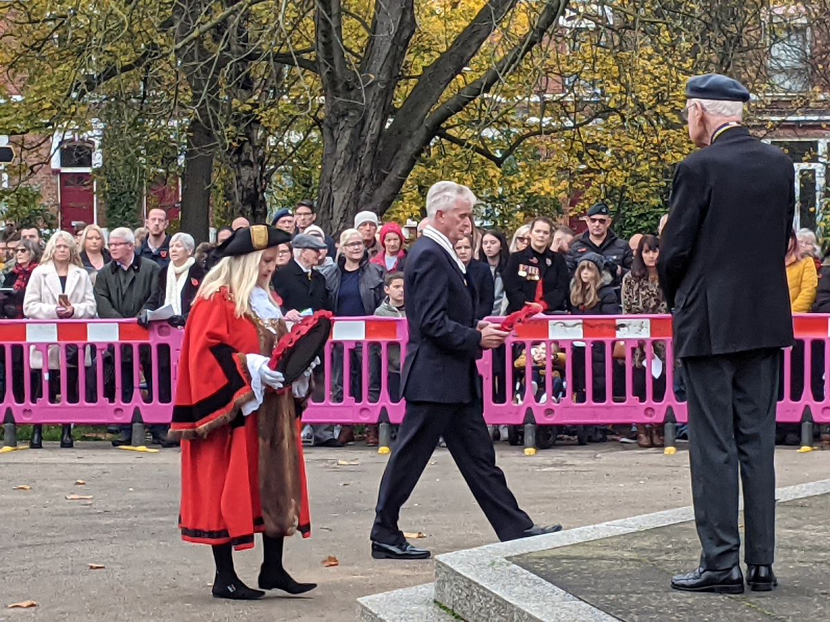 Mayor of Rotherham, Councillor Jenny Andrews, approaches Clifton Park cenotaph holding a poppy wreath at the 2021 Rotherham Remembers event