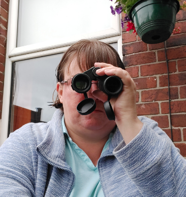 A woman looking through a pair of binoculars.