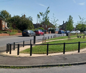 Black fencing around the grass and path area.