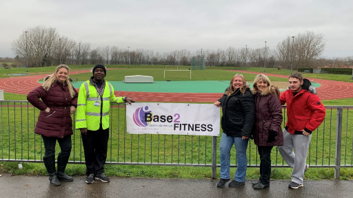 The Base2 staff holding a banner at the side of Herringthorpe Stadium athletics track