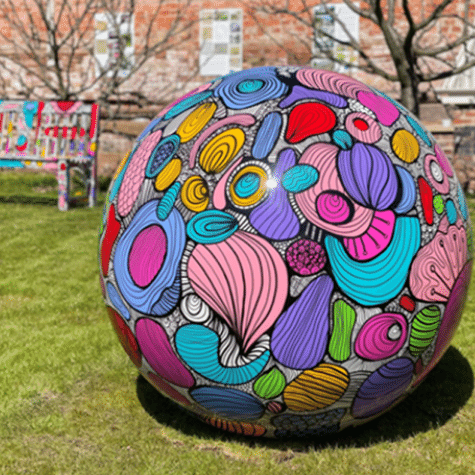 Large outdoor spherical sculpture, smooth and brightly painted.