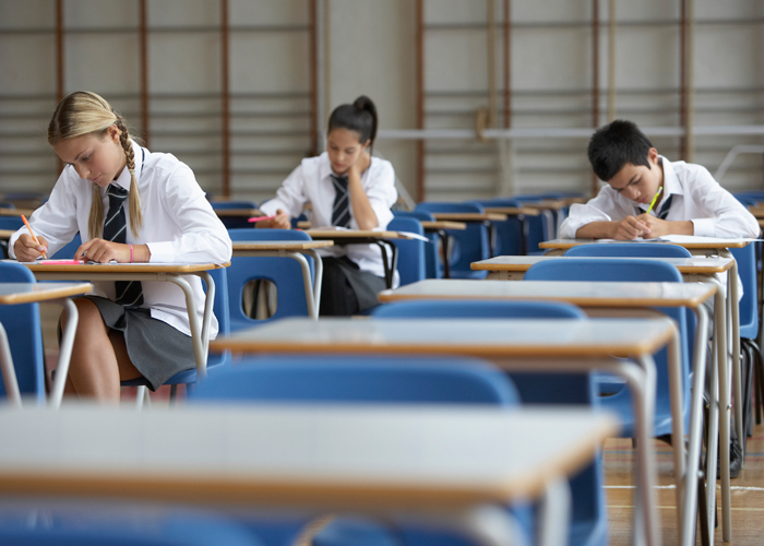 Students sat in sports hall doing exams