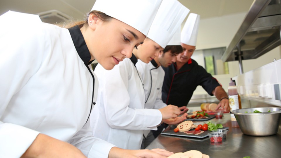 Young people cooking in professional kitchen