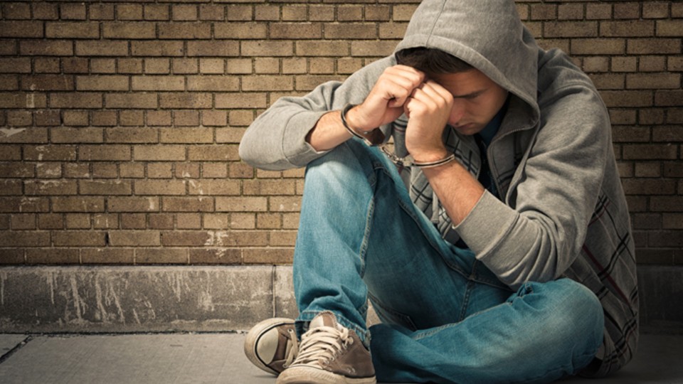 Boy in hoody sat on floor