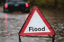 flood road sign with flooded road in background