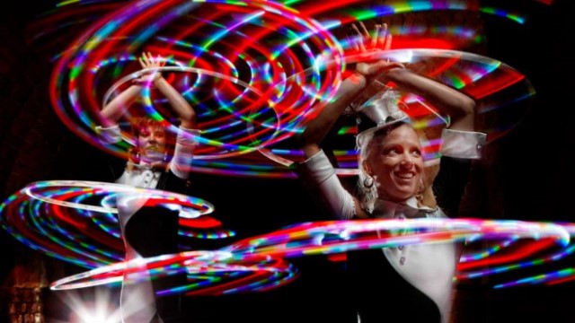 Halo perfomers dancing with illuminated hoops