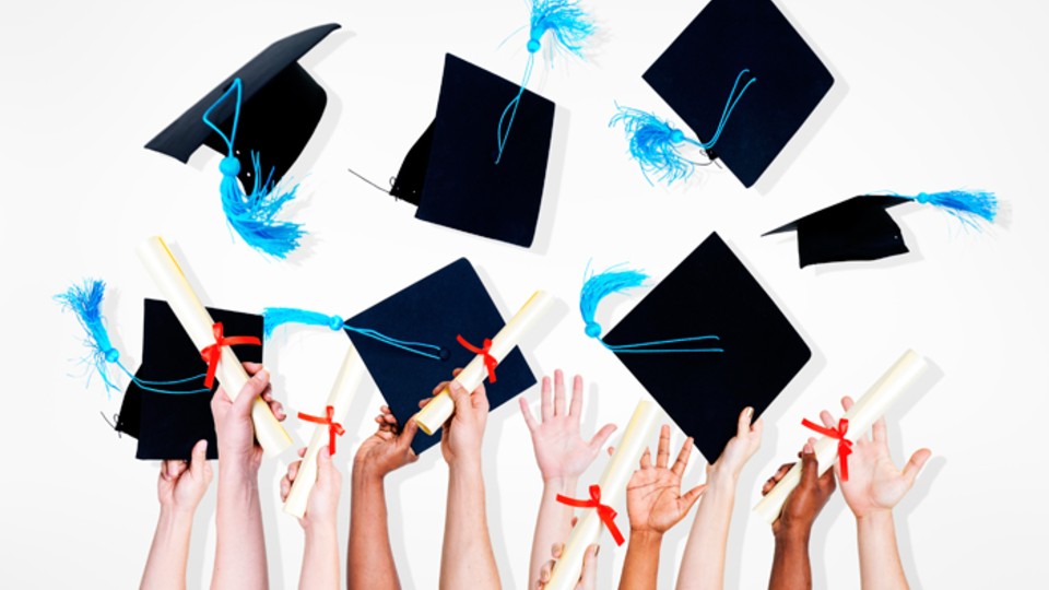 Mortar boards being thrown in the air