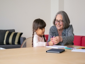 An adult and a child playing at a desk