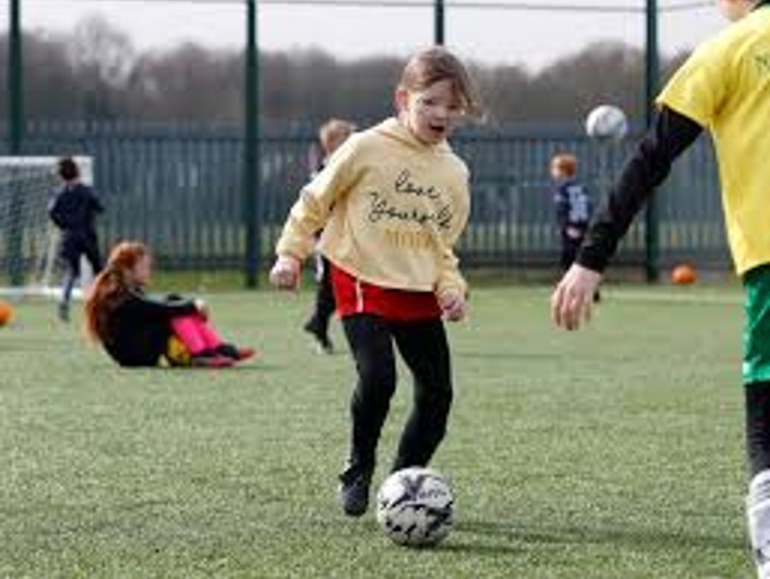RUCST girl learning football skills