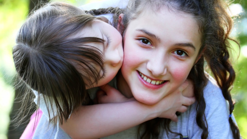 Young child cuddling teen girl