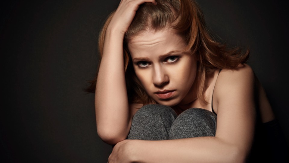 Young woman crouching looking worried