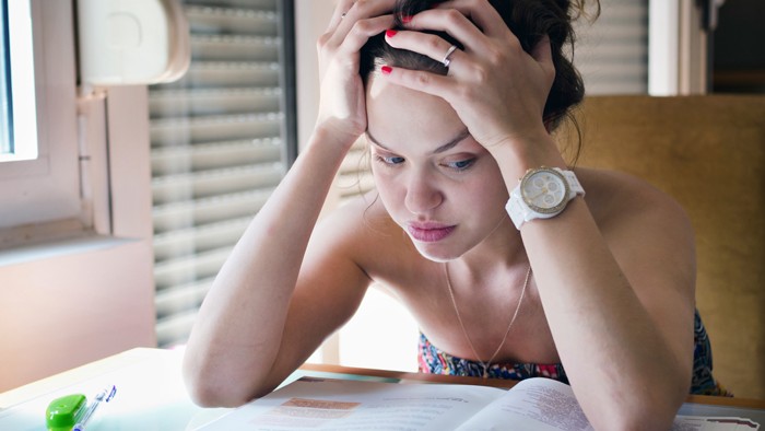 Young woman holding head in her hands