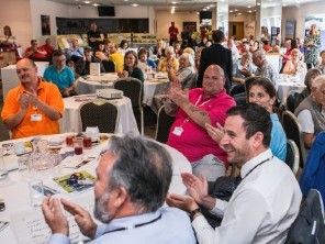 People at the Tenants Open Day event sat around tables clapping
