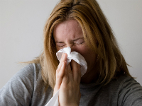 A woman blowing her nose