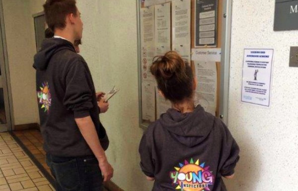 Young inspectors reading building notice board